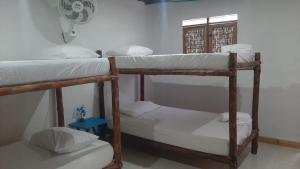 a room with two bunk beds and a window at Hostal El Nido del Azulejo in Barú