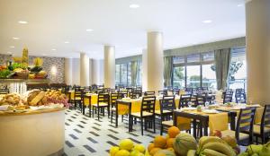 オレビックにあるアミネス グランド アズール ホテルのダイニングルーム(黄色のテーブル、椅子、食べ物付)