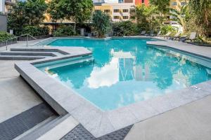 a swimming pool with blue water in a building at Vibrant Inner City Living 1 bedroom Apartment in Brisbane