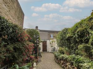 a house with a courtyard with flowers and plants at Victoria Cottage in Amble