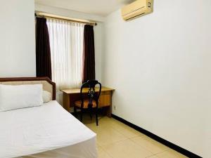 a bedroom with a bed and a desk and a chair at Apartemen Paladian Kelapa Gading Syariah in Jakarta