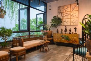 um quarto com plantas, um sofá e janelas em Aaron Boutique Hotel em Nha Trang