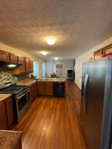 uma cozinha com pisos em madeira e um frigorífico de aço inoxidável em Home sweet home em Columbus