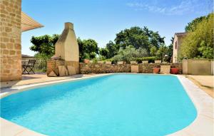 una piscina en un patio con una pared de piedra en Gorgeous Home In Laudun L Ardoise With Kitchen, en Laudun