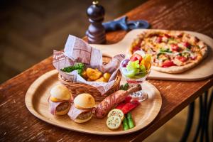 een tafel met een bord eten en een pizza bij Hotel Bali Tower Osaka Tennoji in Osaka