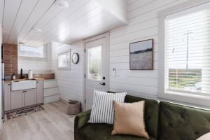 ein Wohnzimmer mit einem grünen Sofa und einer Küche in der Unterkunft Convient tiny home private deck in Apple Valley