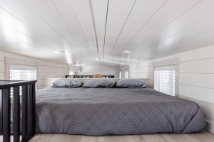 ein Schlafzimmer mit einem großen Bett in einem weißen Zimmer in der Unterkunft Convient tiny home private deck in Apple Valley