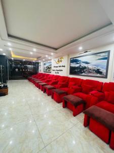 una sala de espera con sillas rojas y una gran pintura en Sapa Land Hotel, en Sa Pa