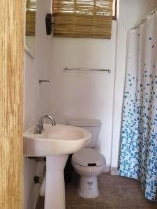 a bathroom with a white sink and a toilet at HOTEL AVE FENIX in Mazunte