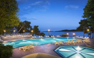 奧瑞比克的住宿－阿米內斯格蘭德阿祖爾酒店，一个带躺椅的游泳池以及度假村