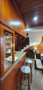 a restaurant with two stools in front of a counter at Duplex estilo europeu Ednamar Apartamentos Bérgamo in Gramado