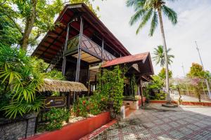 a building with a roof with a palm tree at Holiday Villa Beach Resort Cherating in Cherating