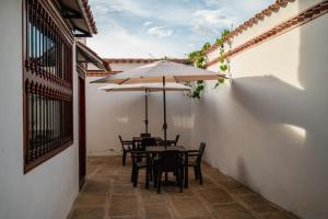einen Tisch und Stühle mit Sonnenschirm auf einer Terrasse in der Unterkunft HOTEL ALTIPLANO VILLA DE LEYVA in Villa de Leyva