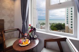 BIDV Beach Hotel Nha Trang في نها ترانغ: طاولة مع طبق من الطعام ونافذة