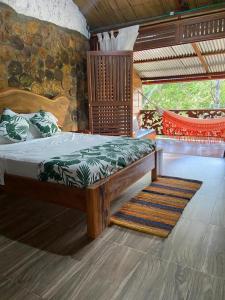 1 dormitorio con cama de madera y alfombra en KOFAN Ecohotel, en Puerto Asís