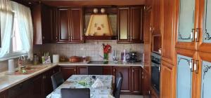 a kitchen with wooden cabinets and a table in it at Giotas House-free parking in Drama