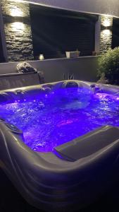 a hot tub with purple lights in a room at Maison vue panoramique et accès SPA in La Réole