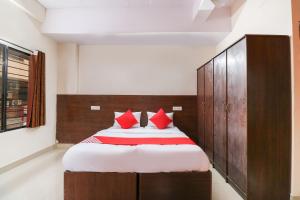 sypialnia z dużym łóżkiem z czerwonymi poduszkami w obiekcie OYO The Royal International Hotel w mieście Bengaluru