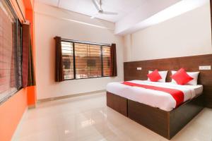 sypialnia z łóżkiem z czerwonymi poduszkami w obiekcie OYO The Royal International Hotel w mieście Bengaluru