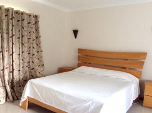 a bedroom with a white bed and a curtain at Spacious apartment in Pereybere 115 m² with shared pool in Pereybere +17 photos