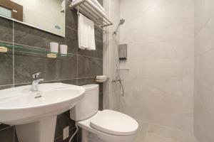 a bathroom with a white toilet and a sink at 花蓮民宿日光漫旅-近東大門夜市 免費停車場 in Hualien City