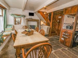 a dining room with a wooden table and chairs at Moldy Warp Barn in Keighley