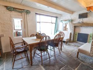 a dining room with a wooden table and chairs at Moldy Warp Barn in Keighley