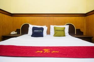 a large bed with two pillows on top of it at Urbanview Hotel Dedy Jaya Brebes in Brebes