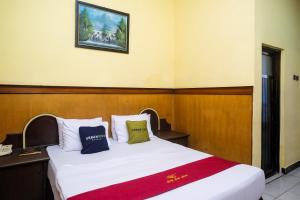 1 dormitorio con 1 cama con una foto en la pared en Urbanview Hotel Dedy Jaya Brebes, en Brebes