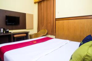 a hotel room with a bed and a television at Urbanview Hotel Dedy Jaya Brebes in Brebes