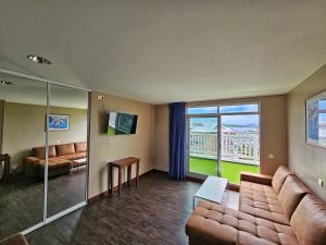 a living room with a couch and a large window at Auberge du MOCAMBO in Noumea