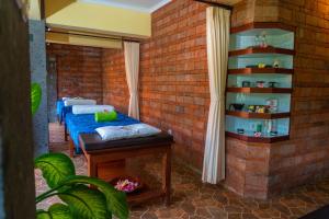 ロビナにあるVilla Selonding Batuのレンガの壁にベッド2台が備わる客室です。
