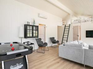 - un salon avec un canapé, une table et des chaises dans l'établissement 12 person holiday home in Bl vand, à Blåvand