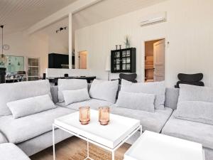 a living room with a couch and a table at 12 person holiday home in Bl vand in Blåvand