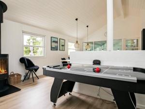 mesa de ping pong en la sala de estar con chimenea en 12 person holiday home in Bl vand, en Blåvand