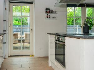 a kitchen with a stove top oven next to a door at 12 person holiday home in Ulfborg in Øby
