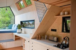 uma cozinha numa pequena casa com uma escada em Green Tiny Village Harz - Tiny House Pioneer 7 em Osterode