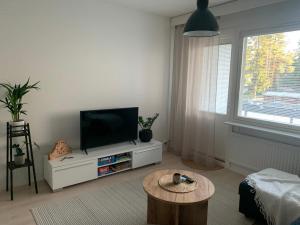a living room with a flat screen tv and a coffee table at 3 h + keittiö ja parveke, juuri remontoitu! in Lahti