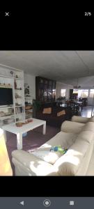 a living room with white couches and a tv at Hostal Renca, Casa Hotel in Santiago