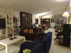 Hostal Renca, Casa Hotel في سانتياغو: غرفة معيشة مع أرائك زرقاء وغرفة طعام