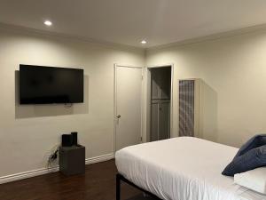 a bedroom with a bed and a flat screen tv at Centrally located UCLA Condo in Los Angeles