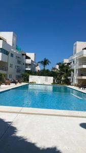 une grande piscine bleue en face de certains bâtiments dans l'établissement Departamento en Acapulco Diamante MacMac, à Acapulco