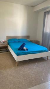- une chambre avec un lit doté de draps bleus et d'une couverture bleue dans l'établissement Departamento en Acapulco Diamante MacMac, à Acapulco