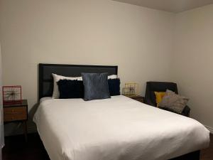a bedroom with a large white bed with pillows at Centrally located UCLA Condo in Los Angeles