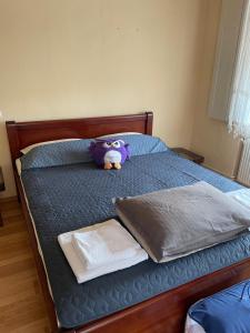 a purple teddy bear sitting on top of a bed at Kuća na selu “ANNA” in Feketić