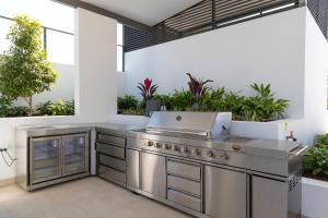 an outdoor kitchen with a stainless steel grill and a patio at Serenity at Solaris 101 in Forster