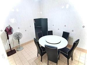 um quarto com uma mesa e cadeiras e uma ventoinha em Welcome Home em Sungai Petani