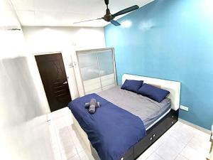 a blue bedroom with a bed with a ceiling fan at Welcome Home in Sungai Petani
