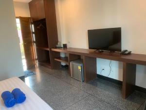 a room with a desk with a flat screen tv at The C Hotel in Amnat Charoen