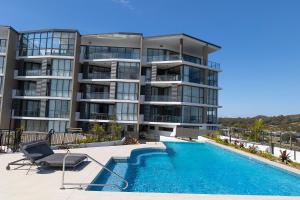 a large apartment building with a swimming pool in front of it at Solaris 606 in Forster